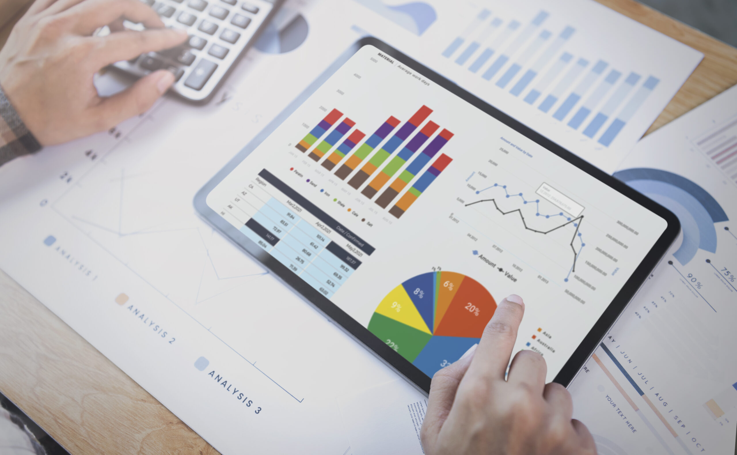 Analytische Auswertung im SAP Ariba Spend Management: Tablet mit Dashboards und Diagrammen zu Finanz- und Einkaufsdaten wird von einer Person im Büro analysiert.